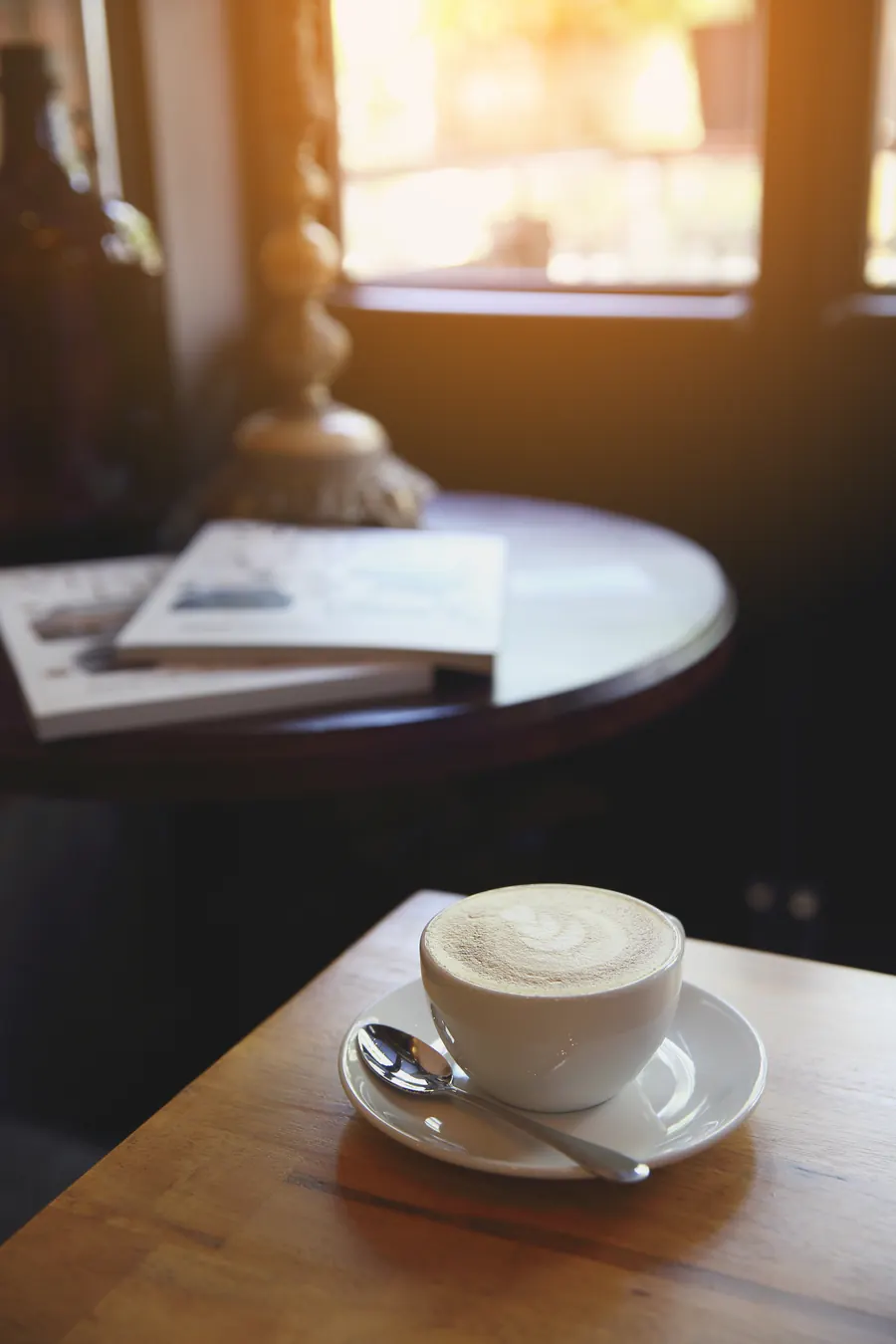 Livre de poche sur une table de café près d'une fenêtre