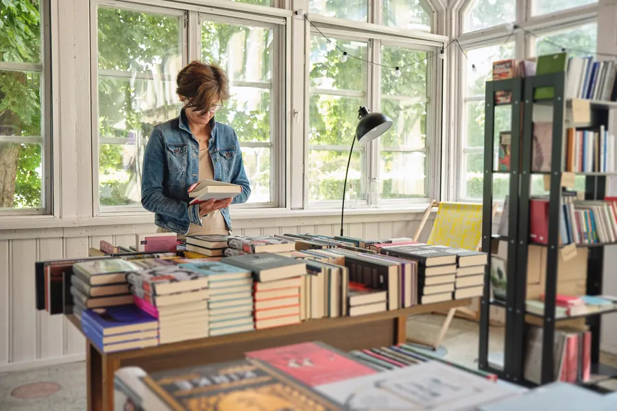 Rayonnages de romans dans une librairie, lumière chaude