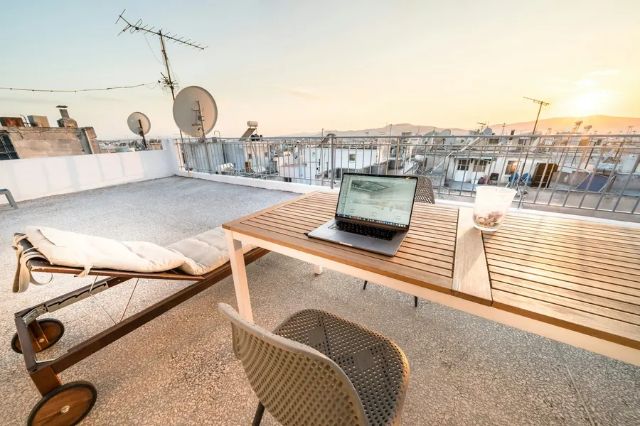 Petite terrasse sur le toit d'un duplex, deux transats, toits de la ville en fin de journée