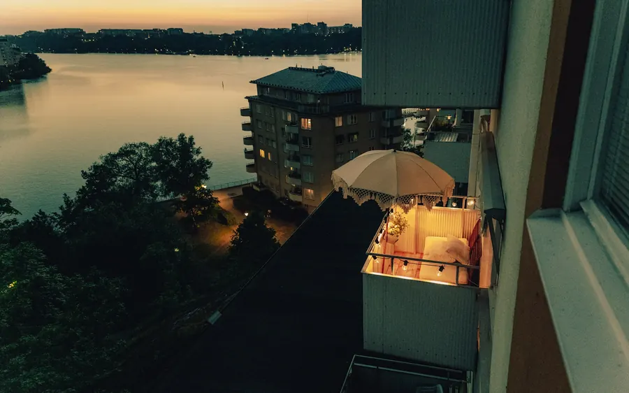 Balcon donnant sur un plan d'eau la nuit, sans bateaux ni chaises visibles