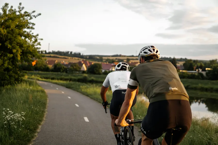 Deux cyclistes sur une piste cyclable entre les marais salants, ciel d'été