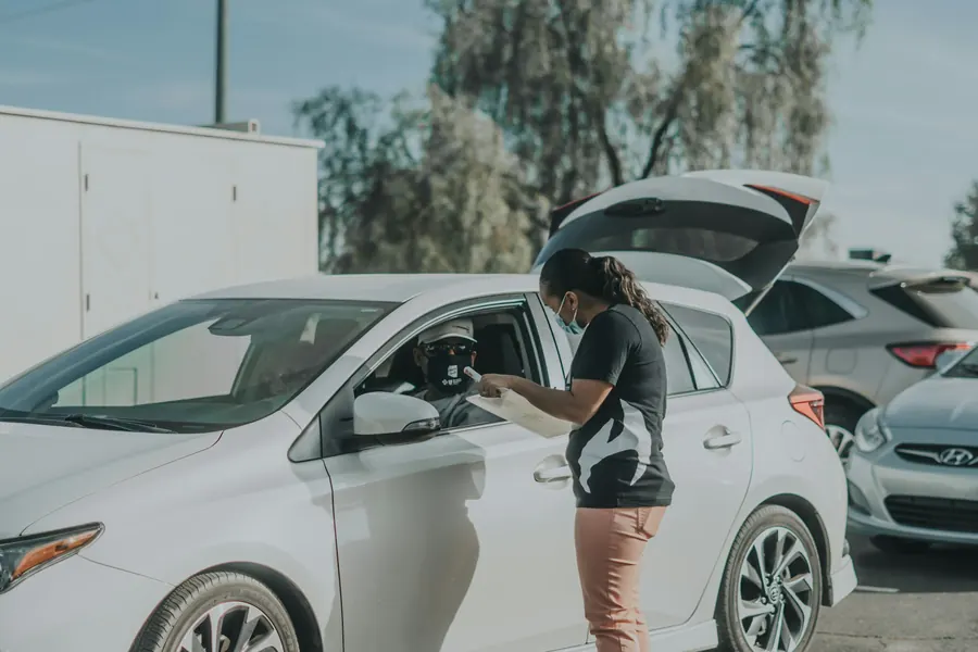 Femme qui inspecte une voiture de location, sans tablette visible