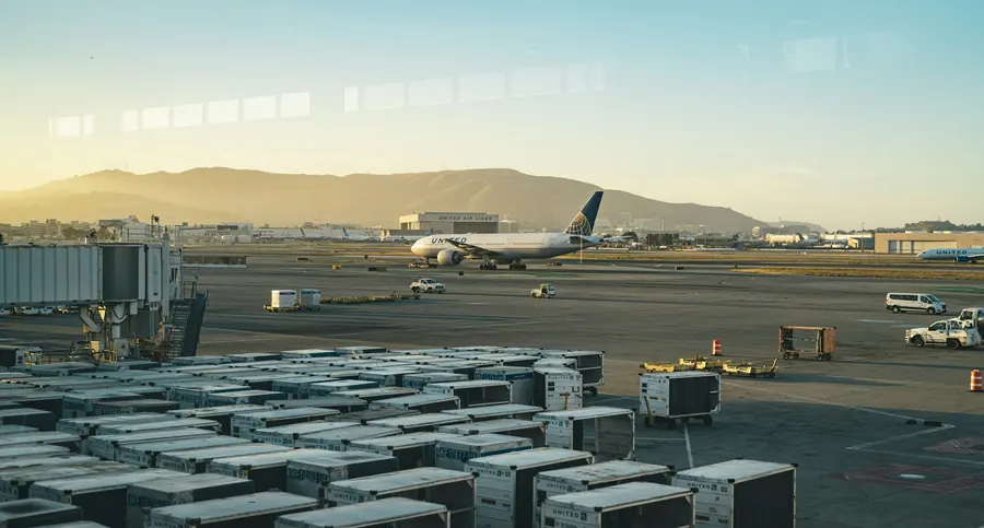 Palettes de fret aérien filmées chargées par une équipe au sol, tarmac, jour