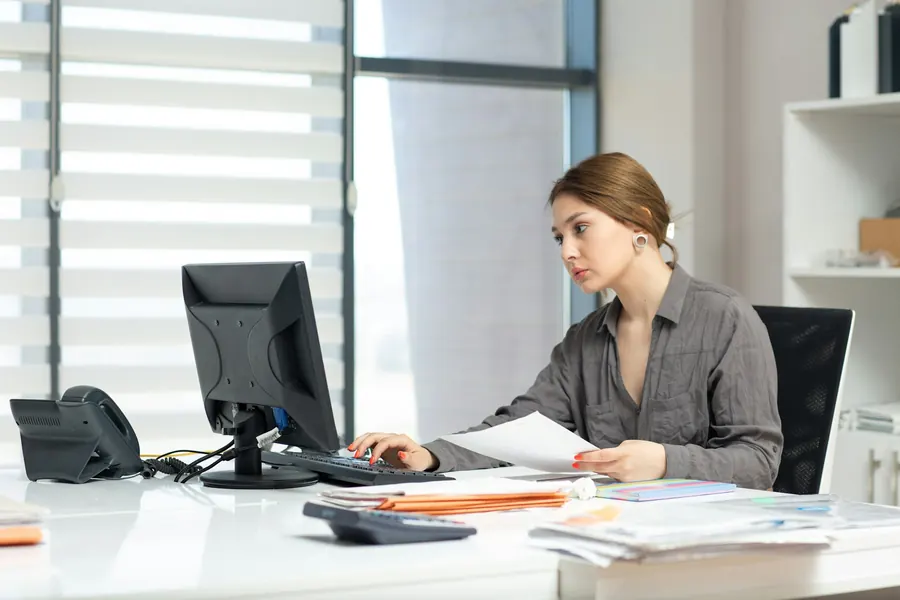 Femme à son bureau avec ordinateur, sans vue sur le port