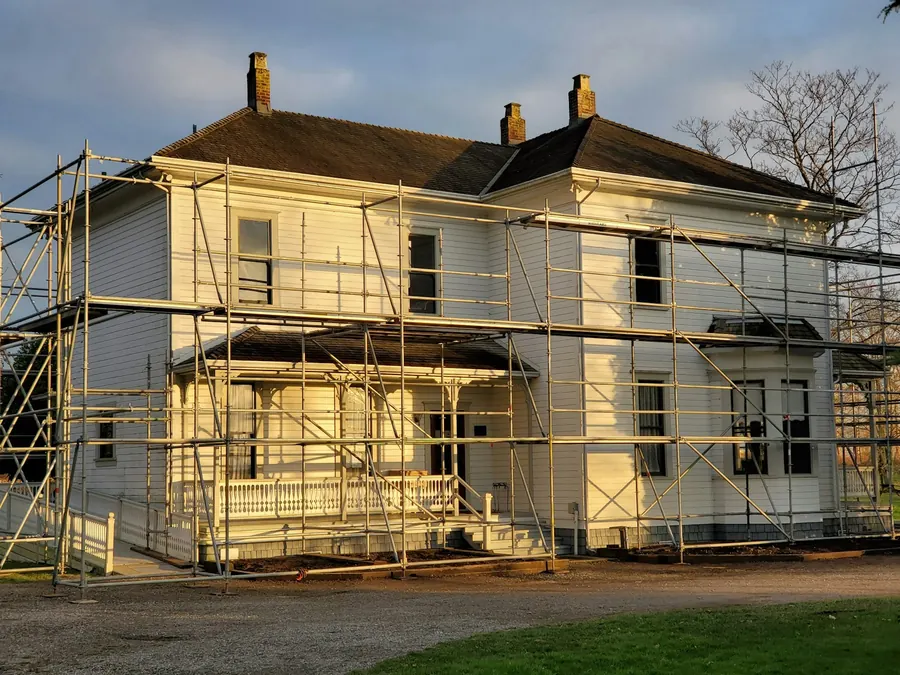Maison en rénovation avec échafaudage, pas en pierre apparente