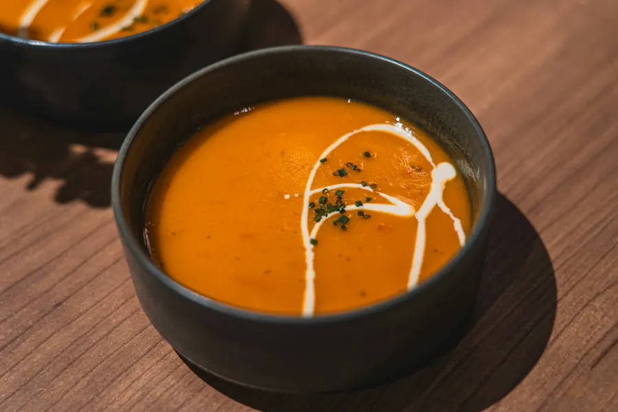Bol de velouté de potimarron sur une table rustique