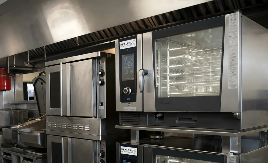 Piano de cuisson inox et four mixte dans une cuisine de restaurant propre