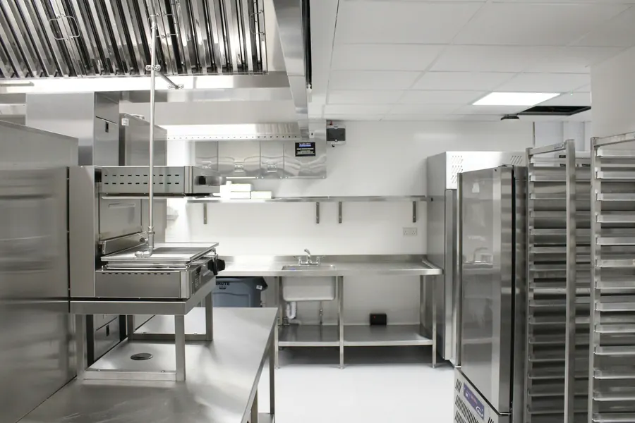 Plans de travail et étagères en inox dans une cuisine neuve, avant l'ouverture