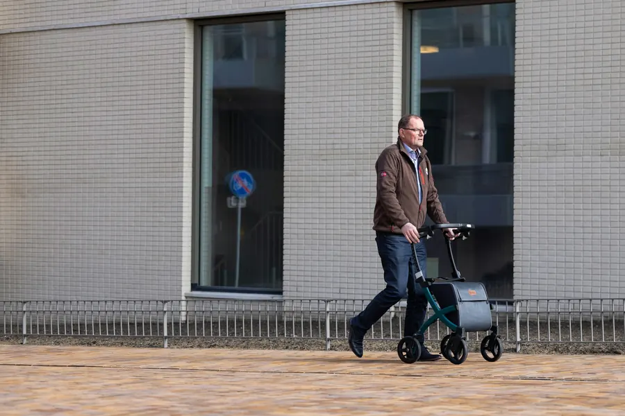Homme d'âge mûr qui marche seul avec un déambulateur