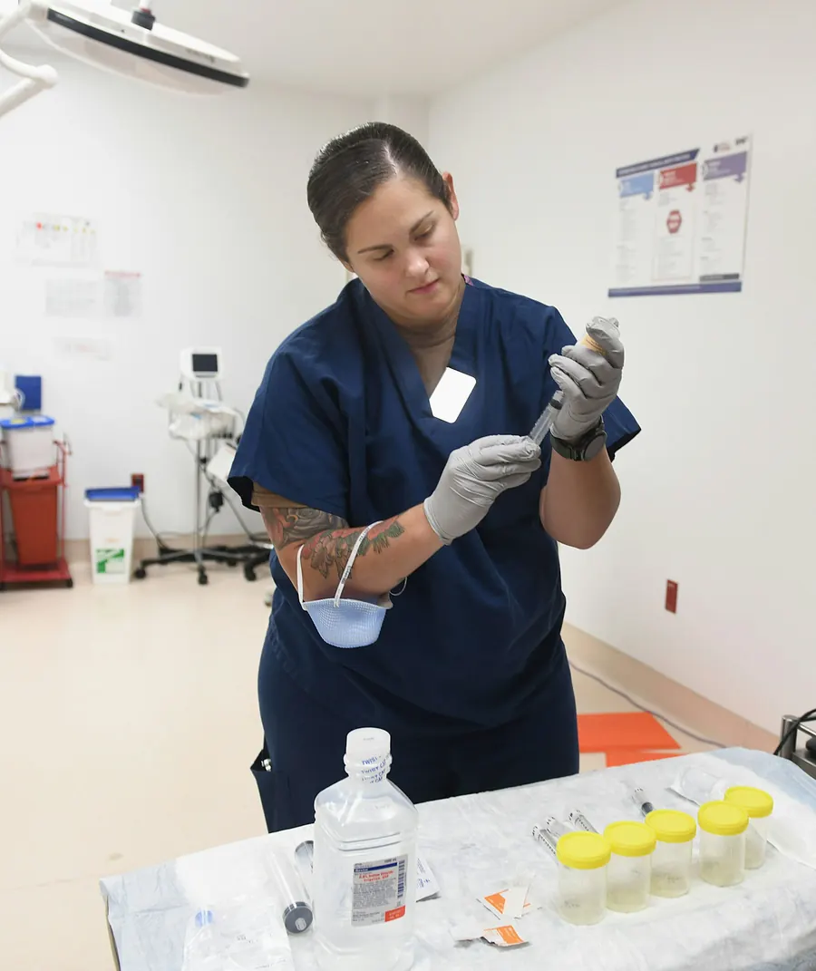 Infirmière qui prépare la salle de soins, draps de protection, gestes précis