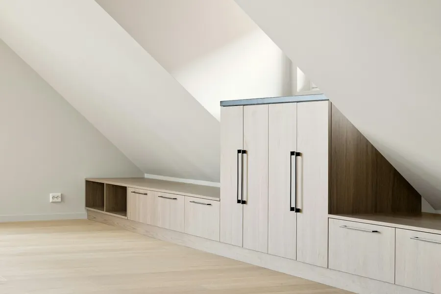 Dressing en bois clair sous un rampant de combles