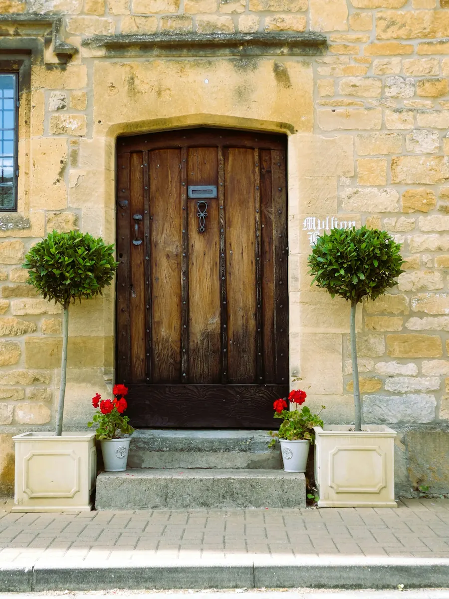 Porte d'entrée en bois massif sur une maison de pierre