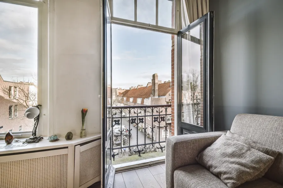 Séjour d'appartement lumineux avec balcon, parquet, vue sur toits