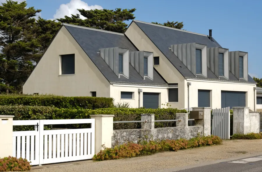 Pavillon des années 70, enduit blanc, toit d'ardoise, jardin