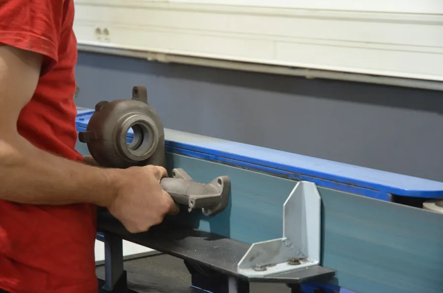 Technicien qui utilise une meuleuse à verres, en polo (pas blouse)