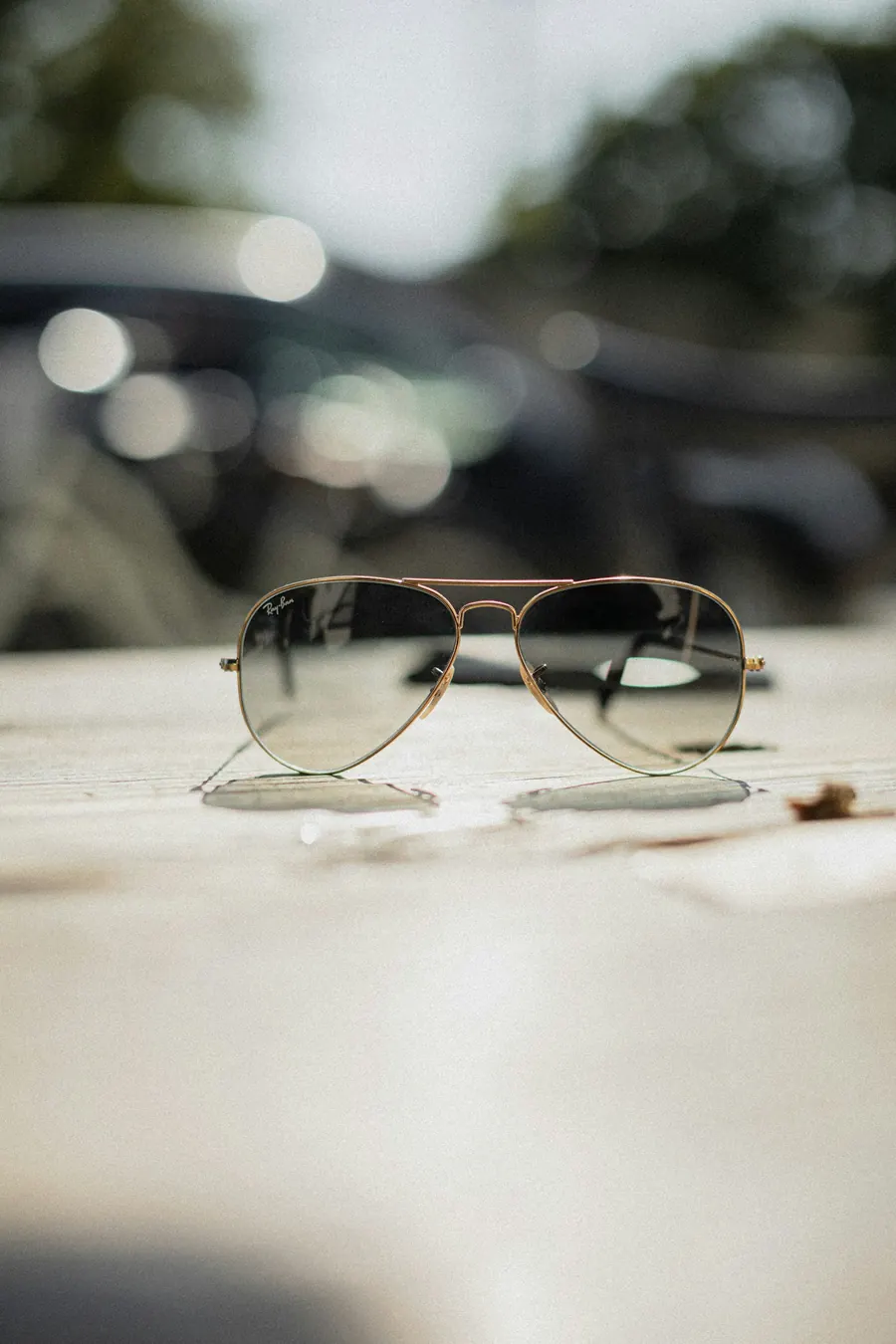 Lunettes de soleil aviateur posées sur une pierre humide, pas sur un présentoir