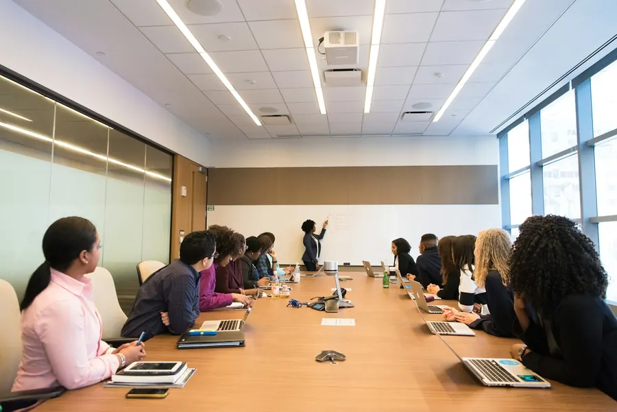Réunion d'ouverture d'audit autour d'une table, documents et ordinateur, lumière du jour