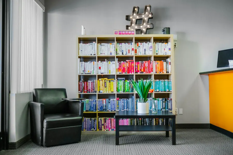 Petit coin d'attente : un fauteuil, une plante, quelques livres, lumière douce