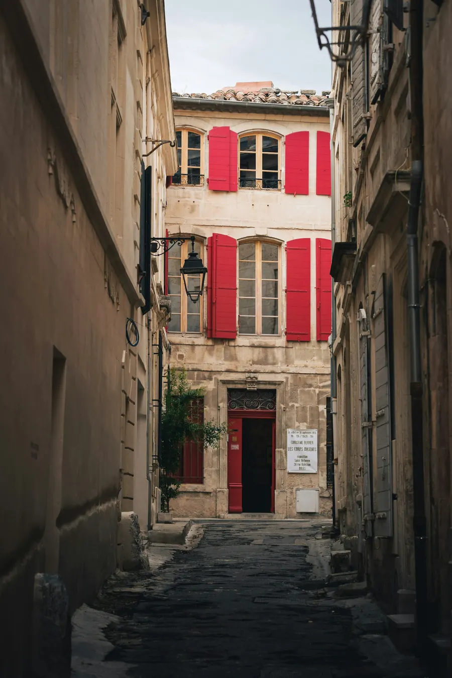 Porte d'entrée d'une maison de ville en pierre claire, petite plaque professionnelle, rue calme de centre-ville vendéen