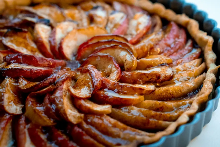 Tarte aux pommes caramélisée sur plan de travail en bois