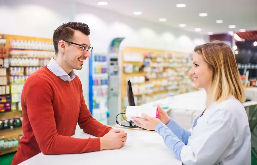 Une pharmacienne au comptoir avec une cliente, officine lumineuse, rayonnages flous