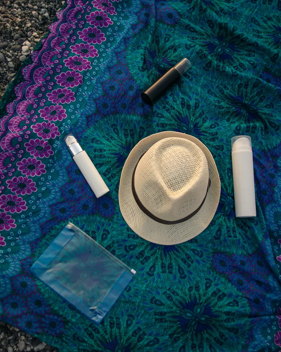 Crème solaire et chapeau de paille dans un sac de plage, lumière d'été