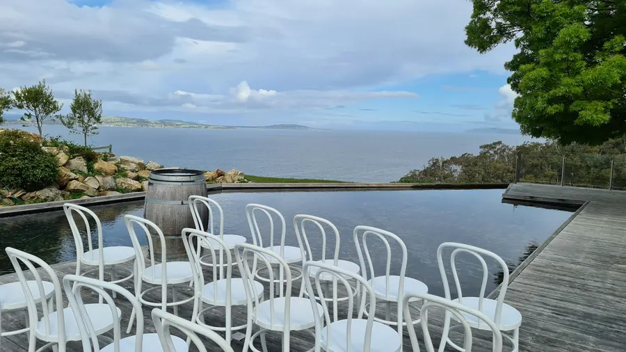 Bassin à débordement au-dessus de la mer, côte rocheuse, ciel changeant