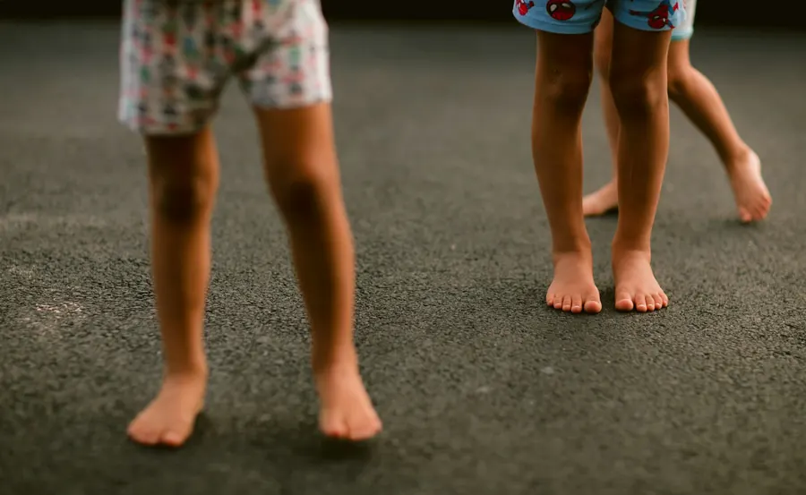 Deux enfants debout pieds nus sur le sol
