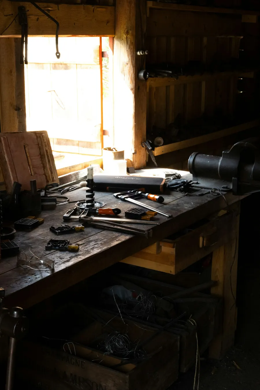 Vieil atelier de menuisier, établi, rabot, planches, lumière de fenêtre