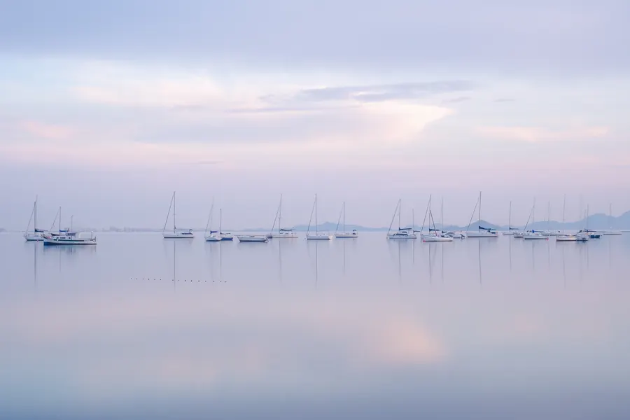 Baie calme au lever du jour, brume légère, lumière douce, aucun personnage