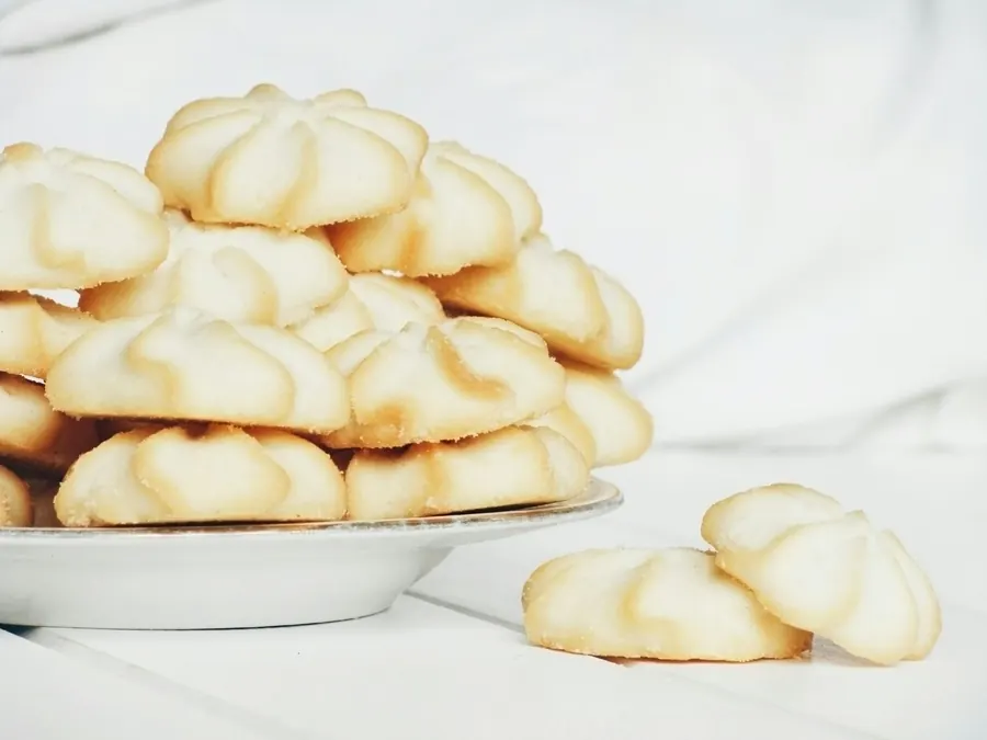 Biscuits sablés en forme de fleur empilés sur une assiette, sans sachet visible