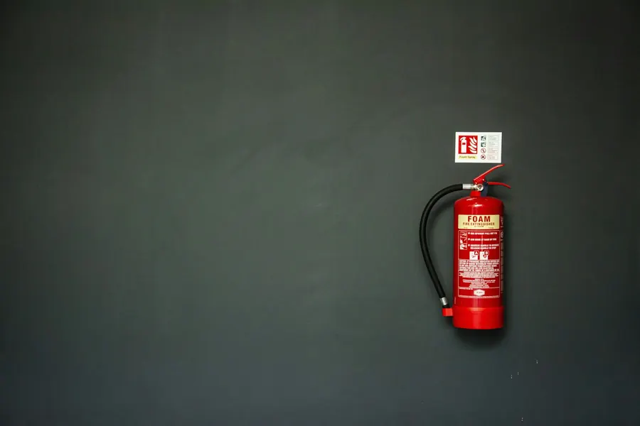 Extincteur rouge fixé au mur, prêt à l'emploi