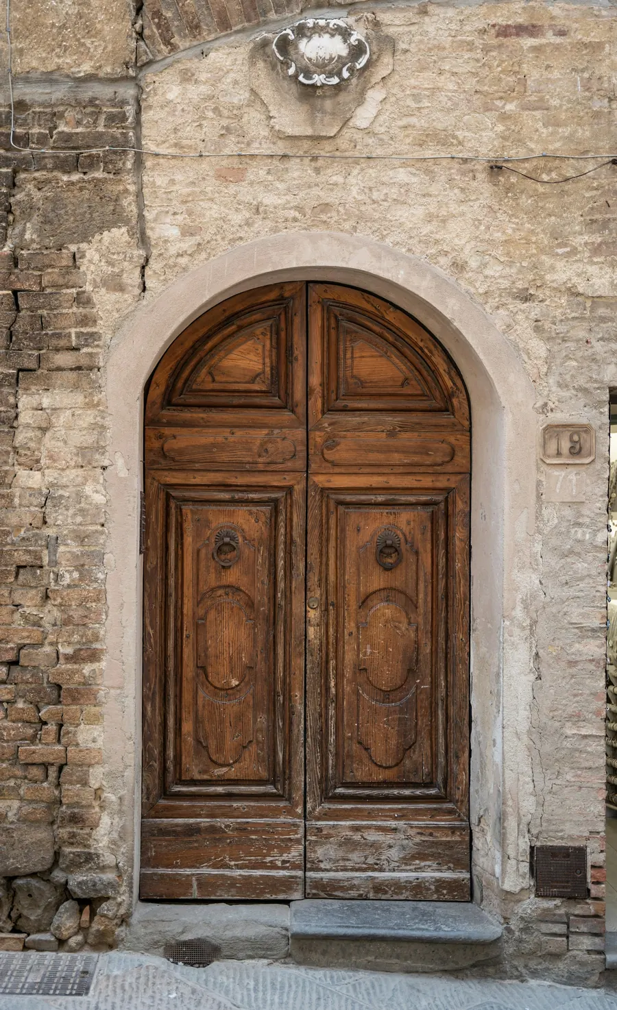 Palier d'un immeuble ancien, porte en bois, plaque discrète