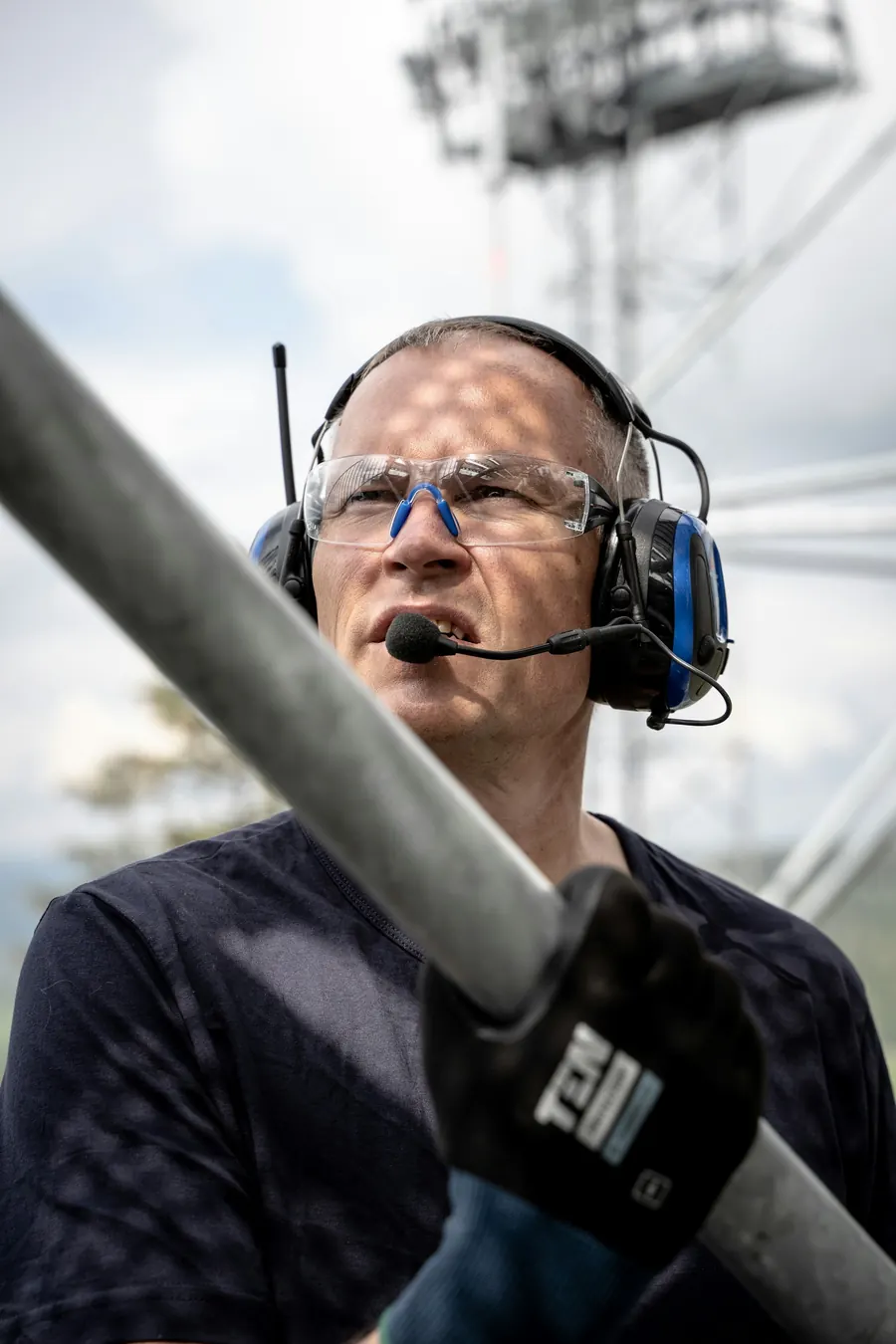 Technicien concentré avec casque et micro, en extérieur, pas de couloir visible