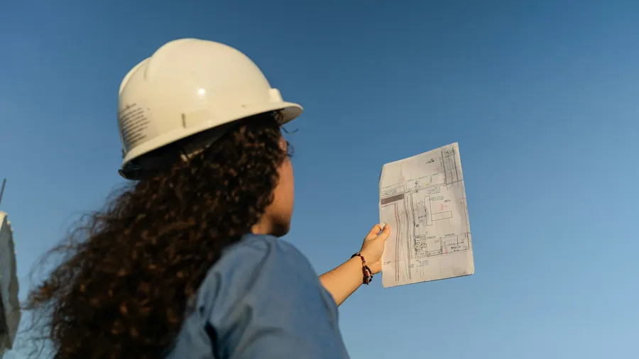 Femme avec casque de chantier qui consulte un document