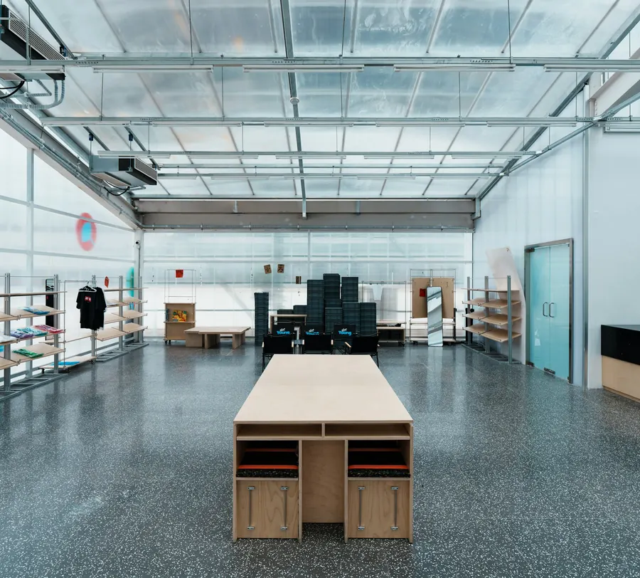 Atelier boutique avec sol en béton gris et verrière lumineuse
