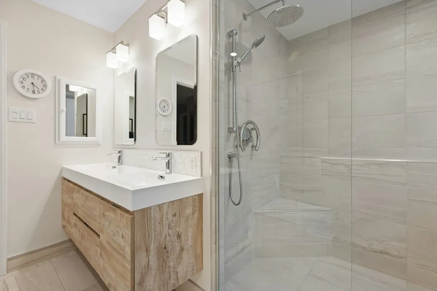 La même pièce après travaux, même cadrage, douche de plain-pied avec paroi fixe