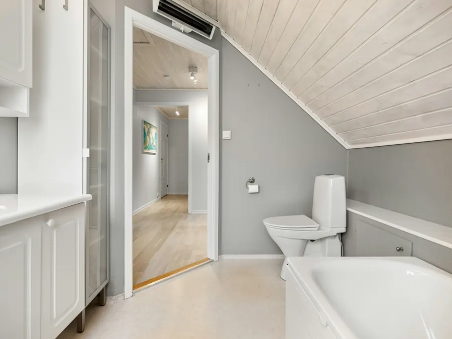 Petite salle d'eau sous rampants, fenêtre de toit au-dessus de la douche