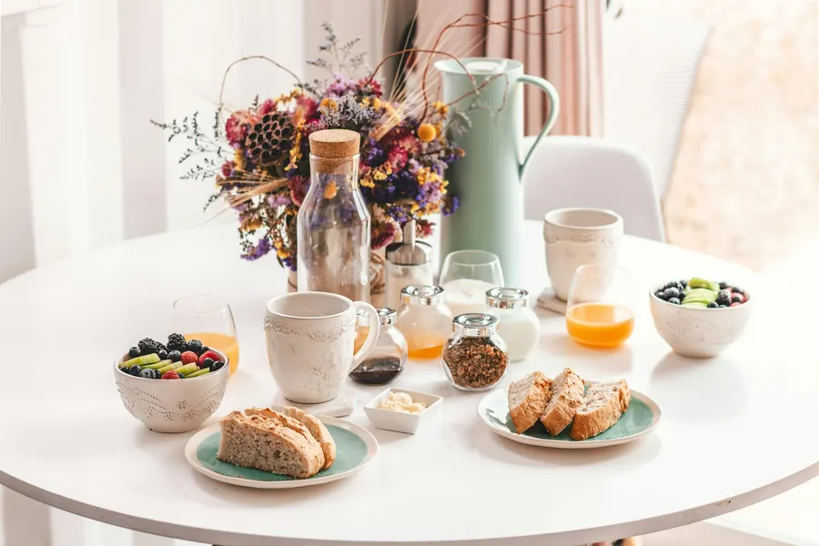 Table de brunch avec pain, confiture, café et fruits, vue en angle