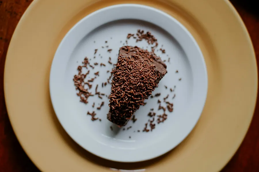 Part de fondant au chocolat saupoudrée de cacao, assiette blanche