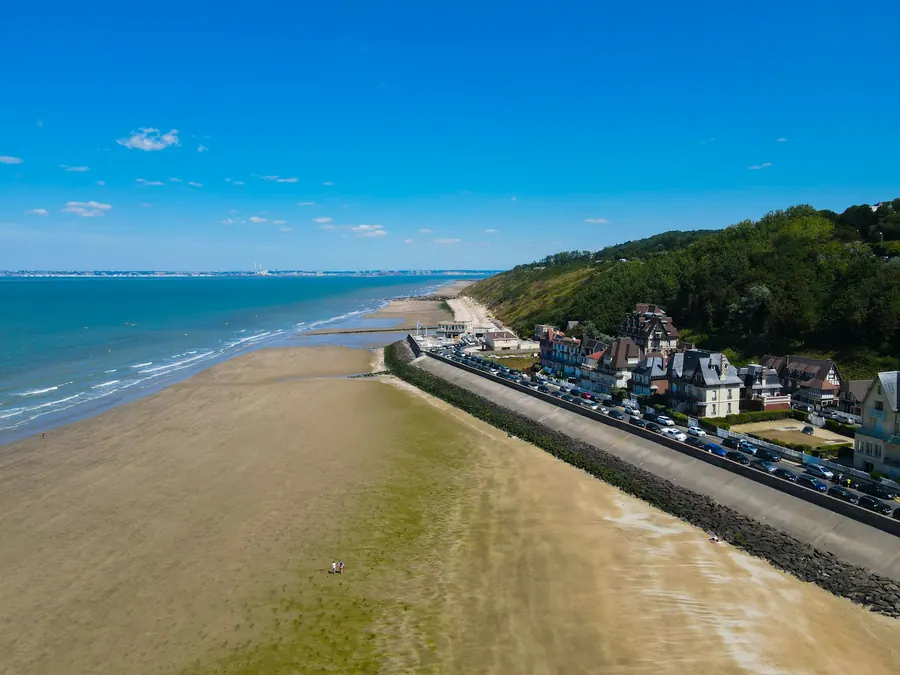 Vue aérienne de plage normande bordée d'une digue et de maisons