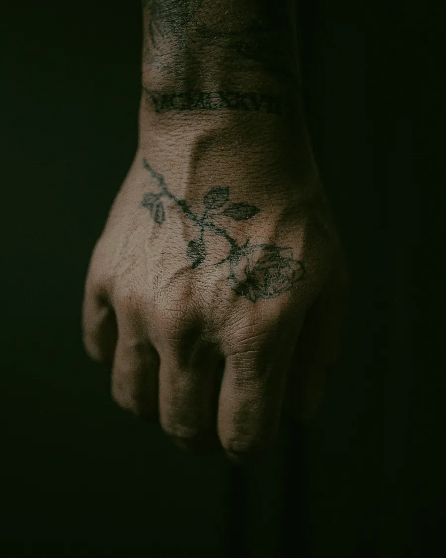 Tatouage floral fine ligne sur le dos de la main