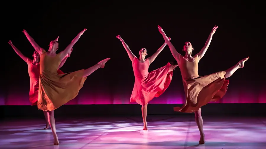 Danseuses contemporaines en mouvement sur une scène aux lumières roses
