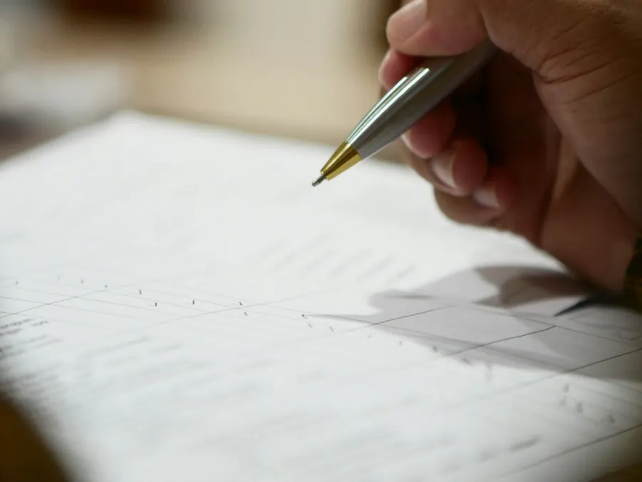 Pages d'un contrat et d'un acte posées sur un bureau, stylo, gros plan