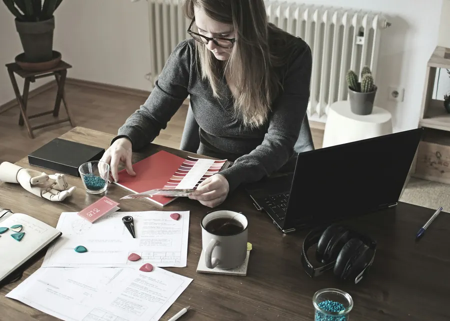 Traductrice à son bureau, documents officiels, dictionnaires et ordinateur, lumière du jour