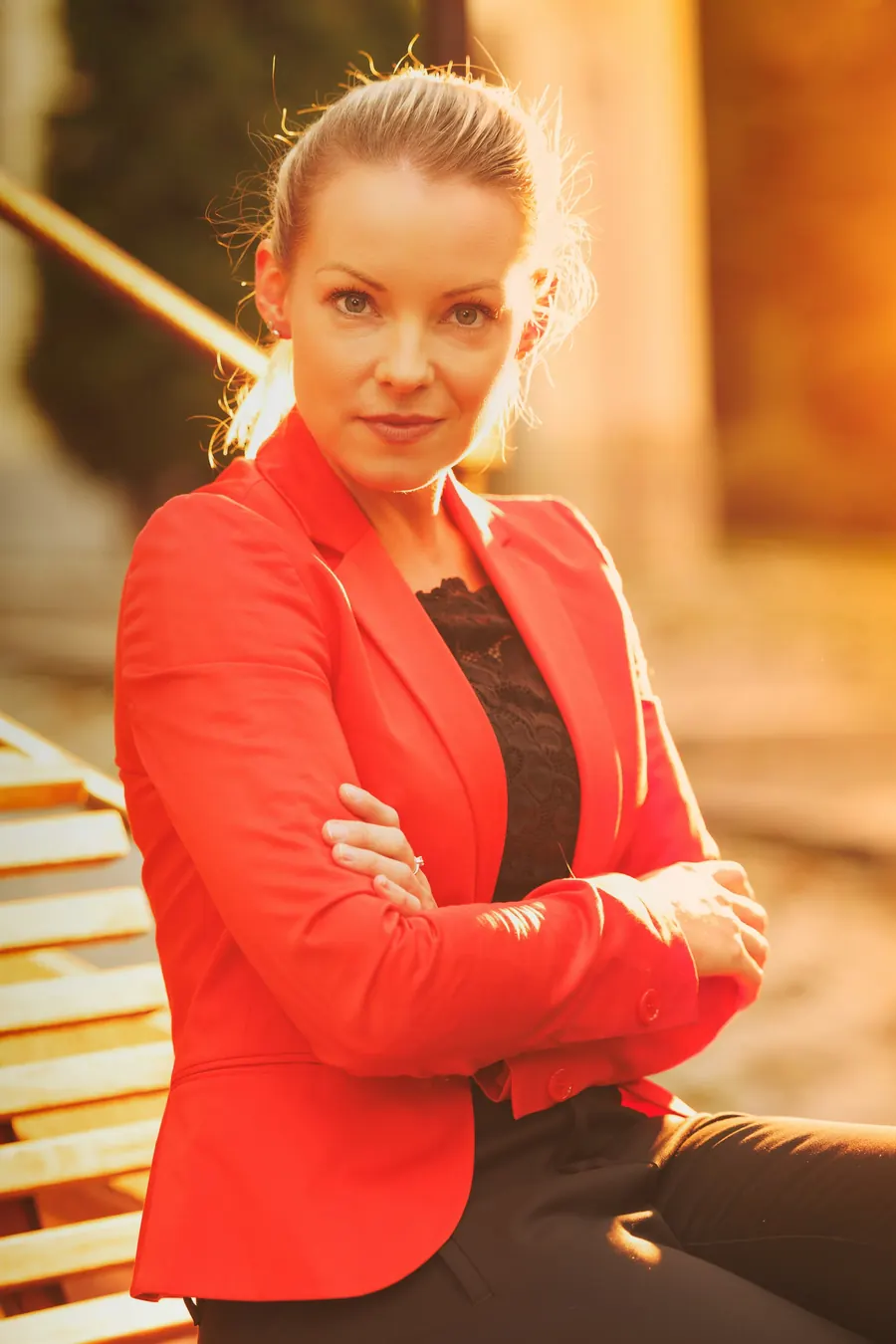 Femme d'âge mûr en blazer rouge, arrière-plan flou, pas de bureau visible