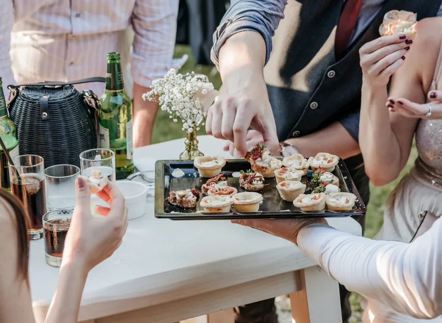 Serveur qui présente un plateau de bouchées lors d'un cocktail d'entreprise