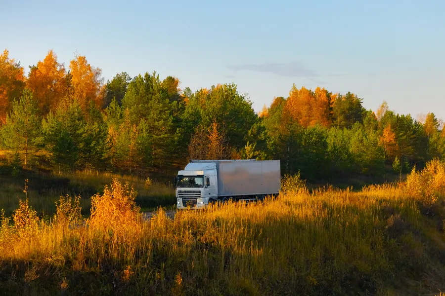Semi-remorque frigorifique blanche sur une route de campagne normande au petit matin