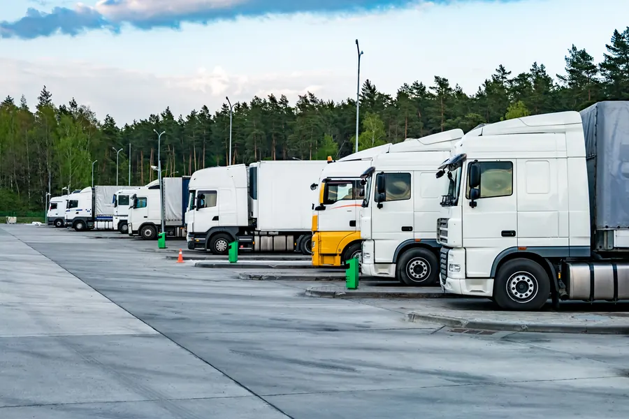 Rangée de camions blancs au dépôt, lumière du matin