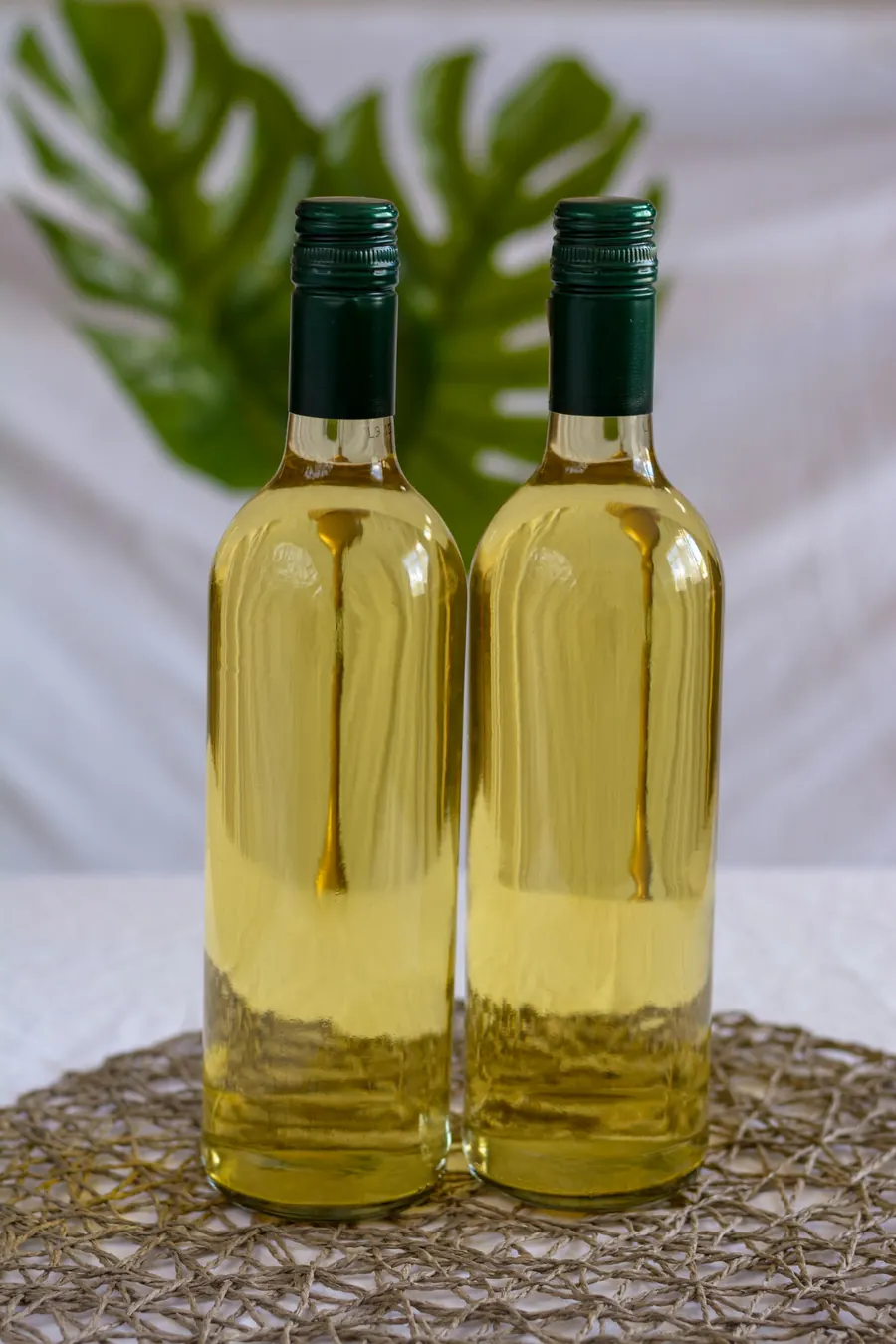 Bouteille de vin blanc à l'étiquette sobre posée sur une pierre calcaire, fond clair